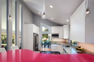 A sleek, modern kitchen in La Honda is accented by a magenta peninsula.