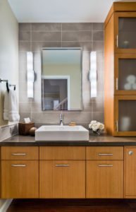 A contemporary bathroom with a vessel sink and plenty of storage.