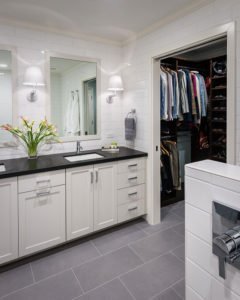 A monochromatic universal design bathroom has a walk-in closet with an extra wide doorway, accessible for wheelchair users.