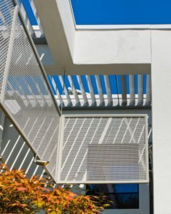 A modern Los Altos Hills home is shaded by mesh screens and metal louvers.