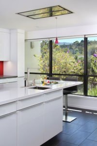 A sleek kitchen island features a second, smaller sink to prepare drinks in Los Altos Hills.