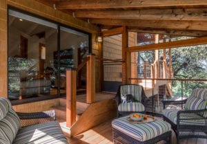 An enclosed patio lounge offers a safe space for cats and their owners to relax.