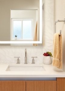 A modern, neutral bathroom in Mountain View adds a touch of interest with a textured tile wall.