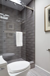 Sliding glass doors and glossy gray tiles give this Los Altos bathroom a sleek, modern feel.