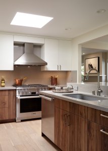 A modern kitchen island is home to both a sink and dishwasher. An elevated bar offers room for casual dining.