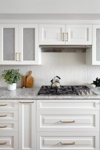 This Los Gatos kitchen's finishes include artful cabinet doors and a textural backsplash.