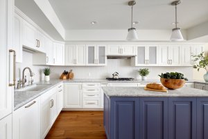 A Los Gatos kitchen features bright white cabinetry and a blue island with some artful finishes.